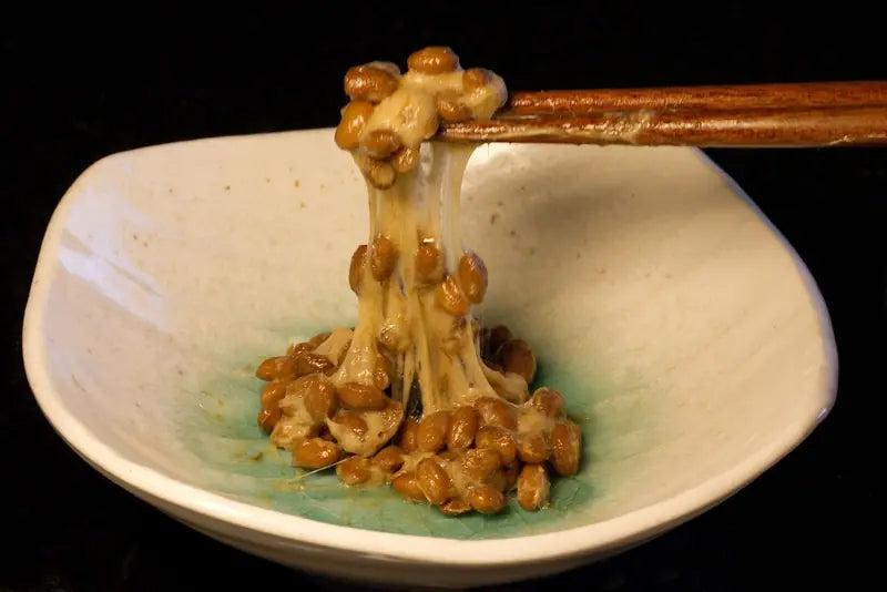 Natto servido, levantado con palillos
